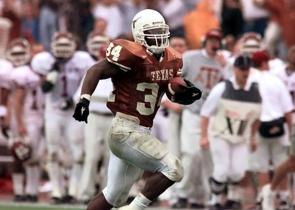 FILE - Texas running back Ricky Williams breaks the all-time NCAA college rushing record as he runs past the Texas A&M bench for a 60-yard touchdown during the first quarter in Austin, Texas, Nov. 27, 1998. (AP Photo/Eric Gay, File)