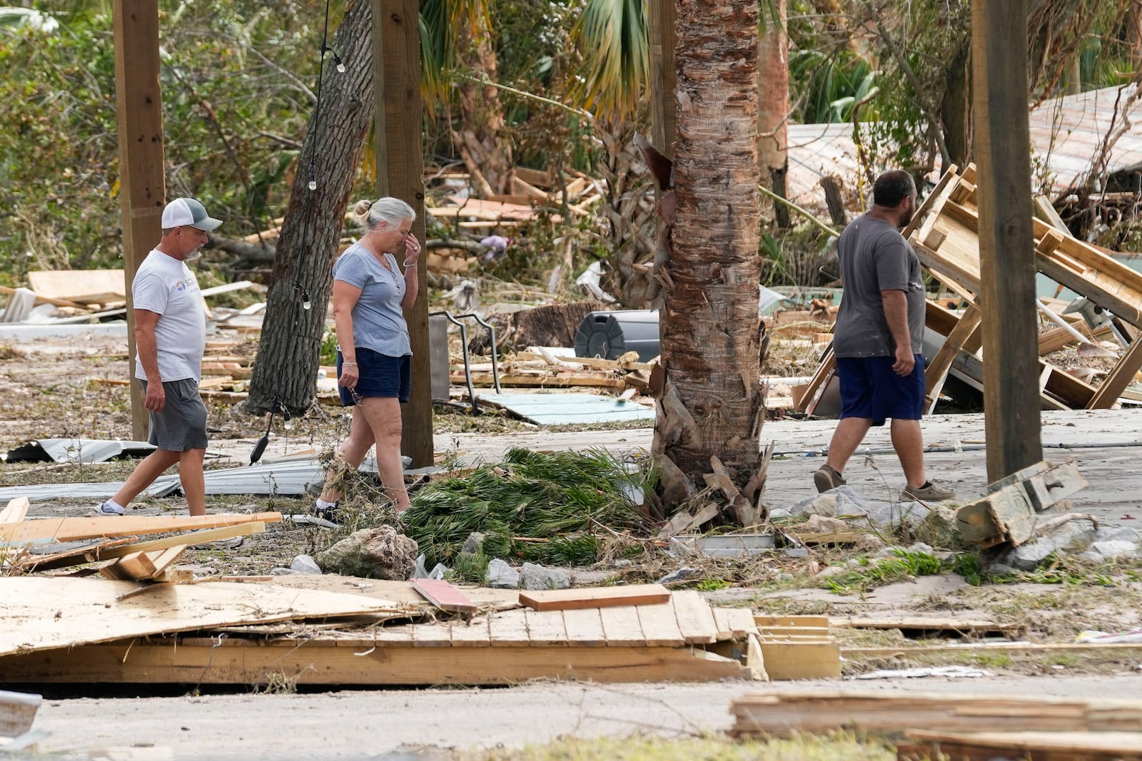 Jennifer Lange, center, walks amid the destruction in the aftermath of Hurricane Helene, in Horseshoe Beach, Fla., Saturday, Sept. 28, 2024. (AP Photo/Gerald Herbert)