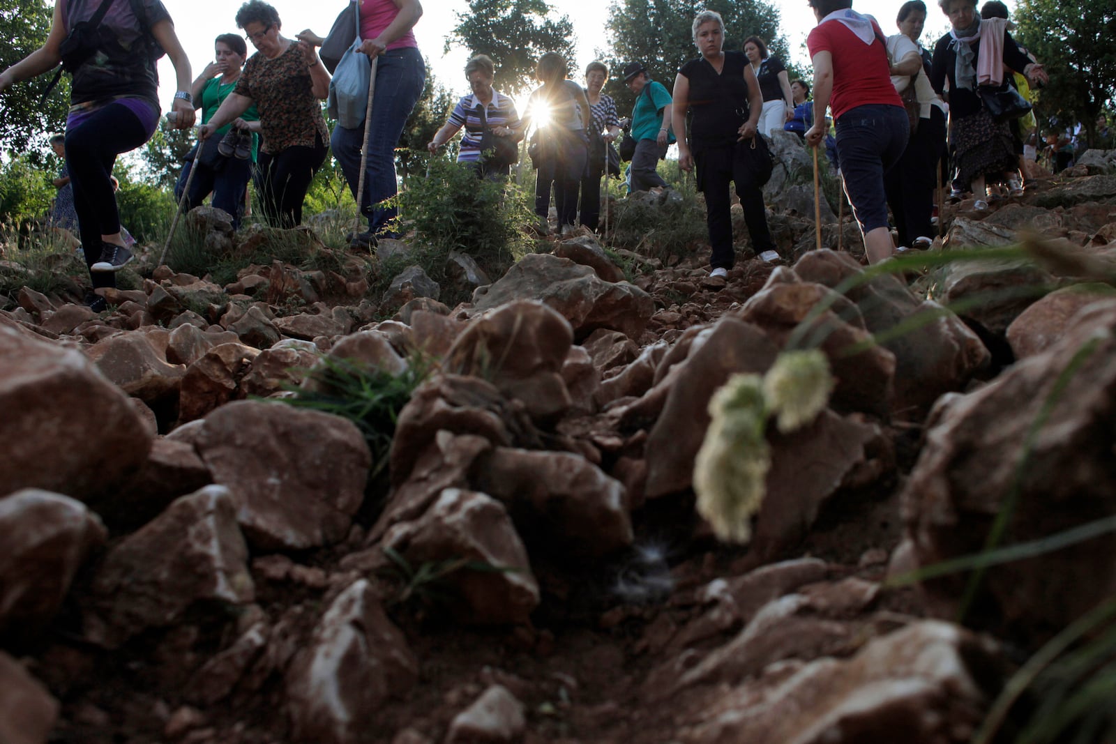 FILE - Pilgrims walk on a rocky terrain to say their prayers on the Hill Of Appearance in Medjugorje, 100 kilometers south of Sarajevo, June 25, 2012. (AP Photo/Amel Emric, File)