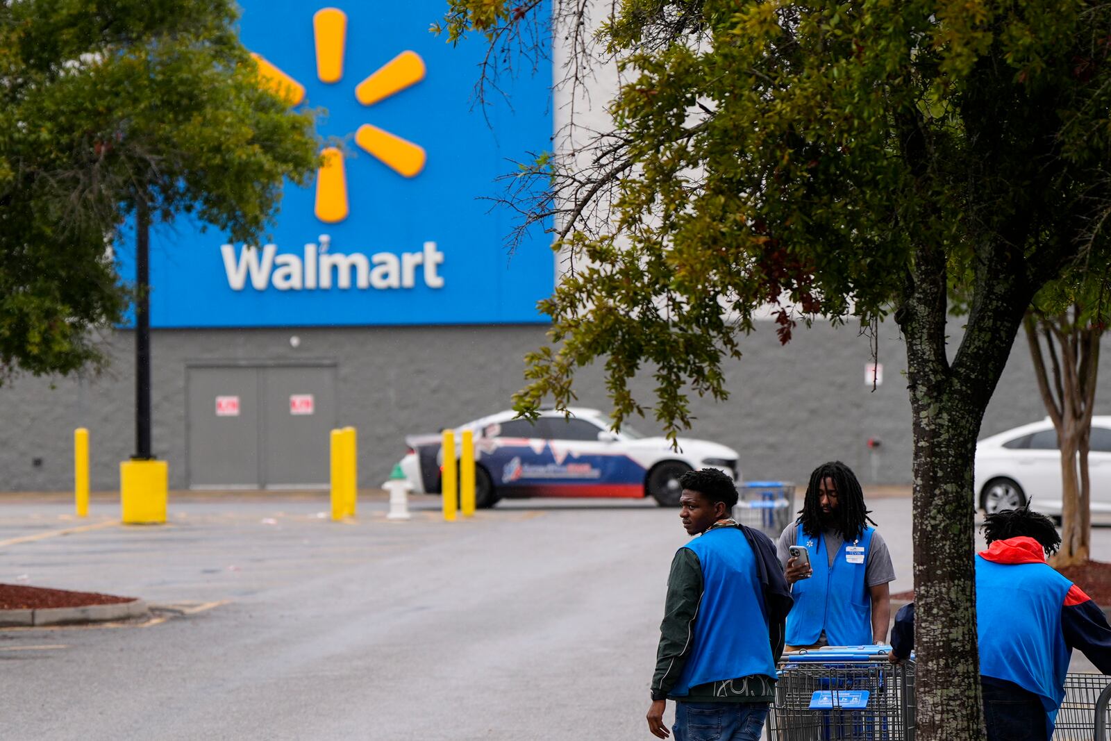 Workers clear shopping carts from the parking lot at a Walmart that just closed ahead of Hurricane Helene, expected to make landfall Thursday evening, Thursday, Sept. 26, 2024, in Valdosta, Ga. (AP Photo/Mike Stewart)