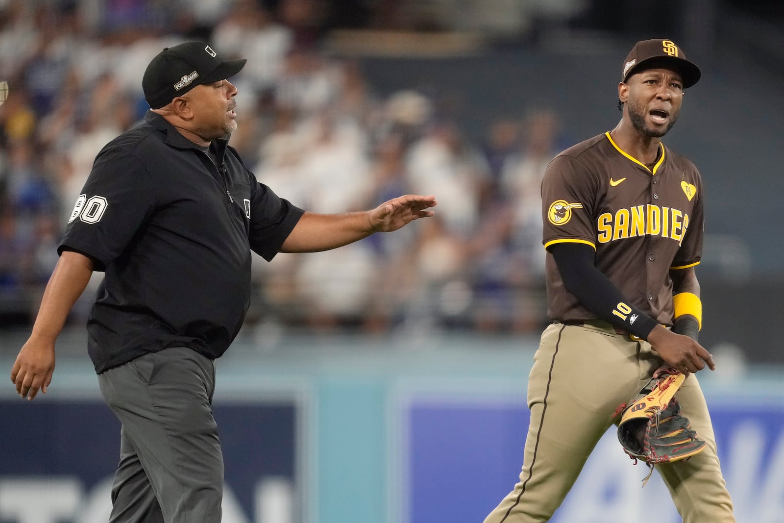 San Diego Padres left fielder Jurickson Profar, right, talks to umpire Adrian Johnson after items were thrown at Profar in the outfield during the seventh inning in Game 2 of a baseball NL Division Series against the Los Angeles Dodgers, Sunday, Oct. 6, 2024, in Los Angeles. (AP Photo/Ashley Landis)