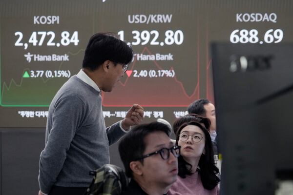 Currency traders work near a screen showing the Korea Composite Stock Price Index (KOSPI), left, and the foreign exchange rate between U.S. dollar and South Korean won, center, at the foreign exchange dealing room of the KEB Hana Bank headquarters in Seoul, South Korea, Tuesday, Nov. 19, 2024. (AP Photo/Ahn Young-joon)