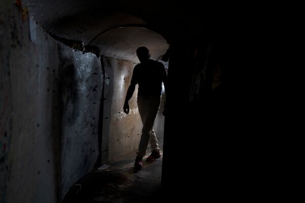 A visitor walks through a replica of a tunnel built by Hamas militants in the Gaza Strip, in a square in Tel Aviv, Israel that is a gathering point for families of hostages held by the militant group, Thursday, Nov. 14, 2024. (AP Photo/Maya Alleruzzo)