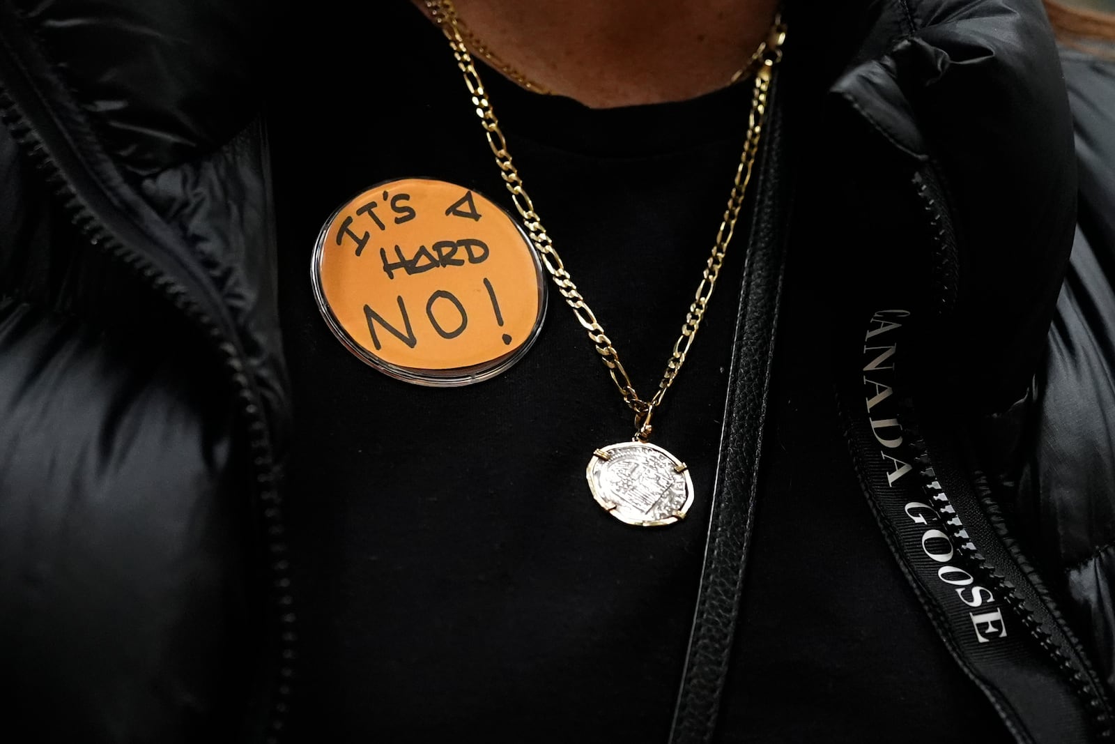 Boeing employee Gina Forbush wears an pin saying "IT'S A HARD NO!" while listening to the announcement that union members voted to reject a new contract offer from the company, Wednesday, Oct. 23, 2024, at Seattle Union Hall in Seattle. (AP Photo/Lindsey Wasson)