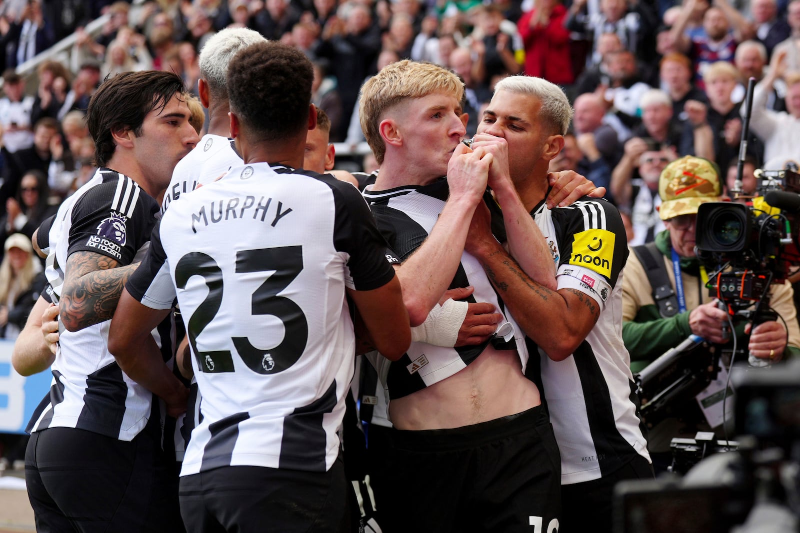 Newcastle United's Anthony Gordon, center, celebrates with teammates after scoring the equalizing goal from the penalty spot during the Premier League match between Newcastle and Manchester City, at St James' Park, Newcastle upon Tyne, England, Saturday Sept. 28, 2024. (Owen Humphreys/PA via AP)