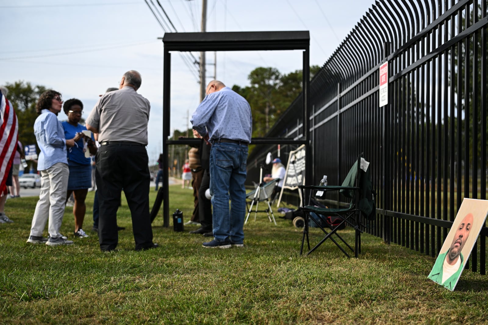 A photo of Richard Moore, right, is propped along a fence as protestors gather prior to Moore's scheduled execution, Friday, Nov. 1, 2024, outside of Broad River Correctional Institution in Columbia, S.C. (AP Photo/Matt Kelley)