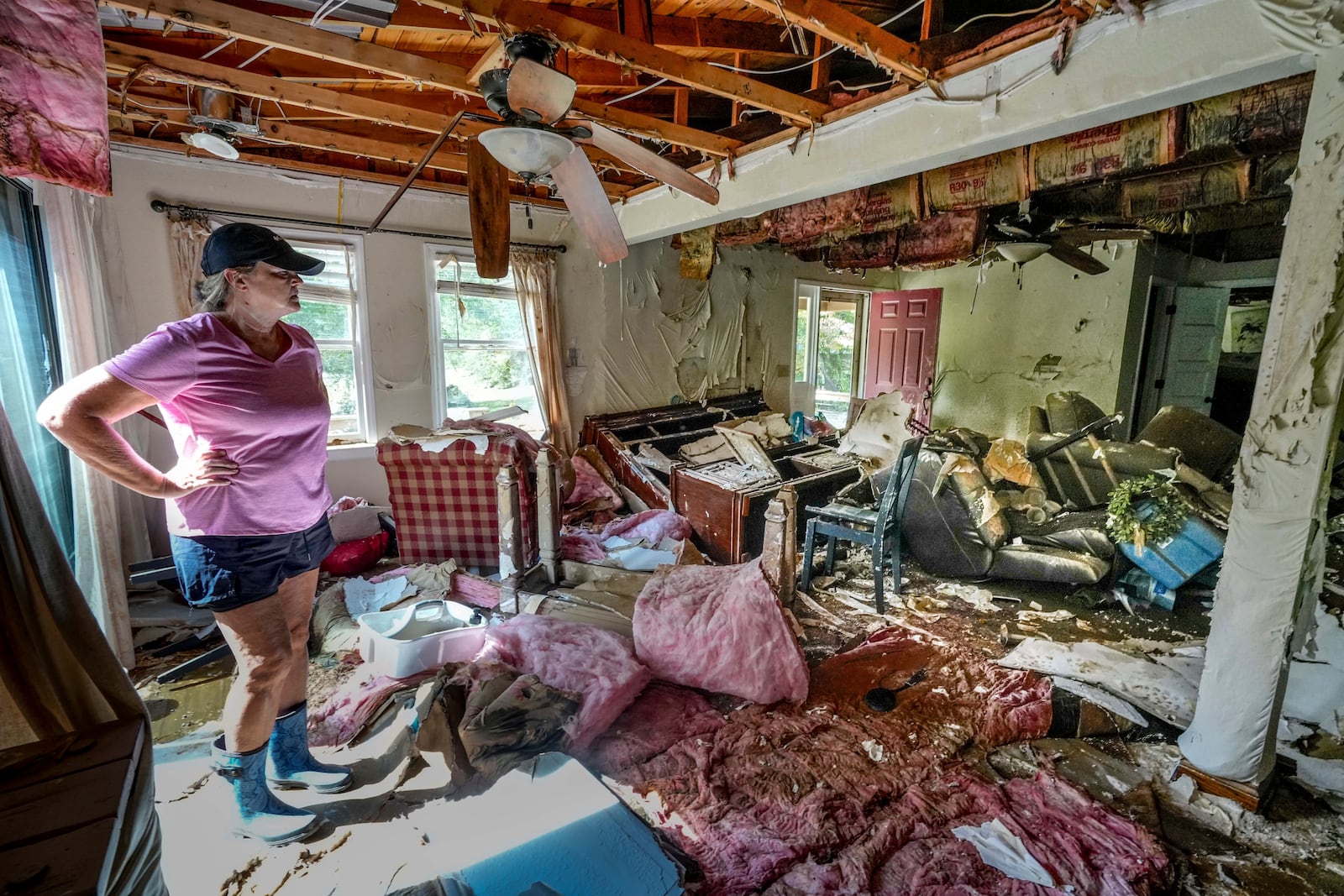 Cindy White looks over the devastation inside her home caused by Hurricane Helene, Tuesday, Oct. 1, 2024 in Morganton, N.C. The adjacent Catawba River flooded due to the torrential rains destroying the seven of family's nine homes on the property. (AP Photo/Kathy Kmonicek)