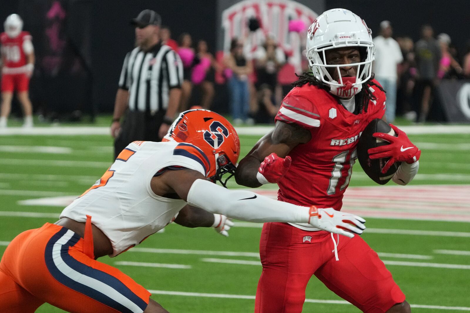 UNLV wide receiver Ricky White III (11) runs around Syracuse defensive back Alijah Clark in the second half during an NCAA college football game, Friday, Oct. 4, 2024, in Las Vegas. (AP Photo/Rick Scuteri)