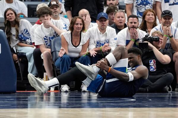 Minnesota Timberwolves guard Anthony Edwards (5) grabs his leg during the first half of Game 2 of an NBA basketball second-round playoff series against the Golden State Warriors, Thursday, May 8, 2025, in Minneapolis. (AP Photo/Abbie Parr)