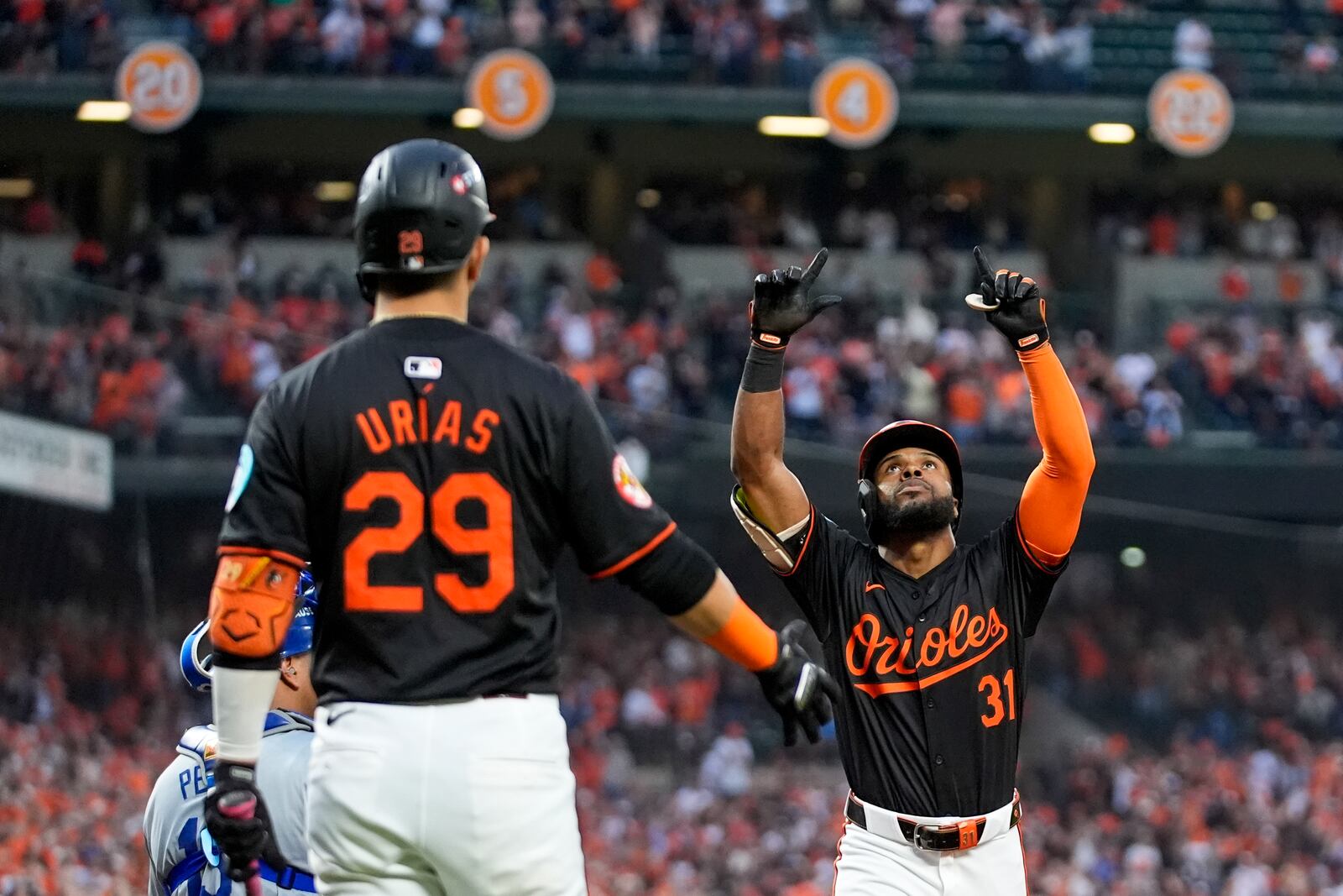 Baltimore Orioles' Cedric Mullins (31), with Ramón Urías (29) looking on, gestures after hitting a solo home run against the Kansas City Royals during the fifth inning in Game 2 of an AL Wild Card Series baseball game, Wednesday, Oct. 2, 2024 in Baltimore. (AP Photo/Stephanie Scarbrough)