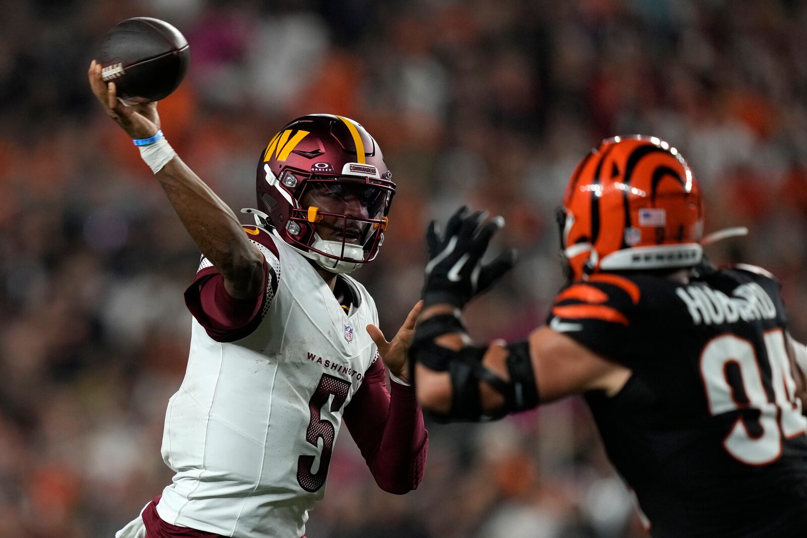 Washington Commanders quarterback Jayden Daniels (5) throws a pass over Cincinnati Bengals defensive end Sam Hubbard (94) during the second half of an NFL football game, Monday, Sept. 23, 2024, in Cincinnati. (AP Photo/Carolyn Kaster)