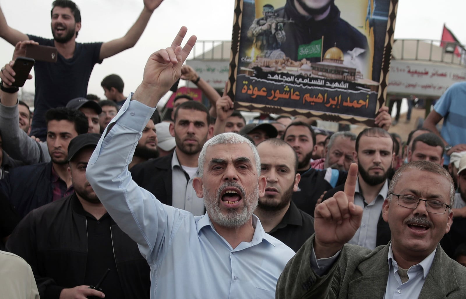 FILE - Hamas leader in the Gaza Strip, Yahya Sinwar, center, chant slogans as he surrounded by protesters during his visit to the Gaza Strip's border with Israel, on April 20, 2018. (AP Photo/ Khalil Hamra)