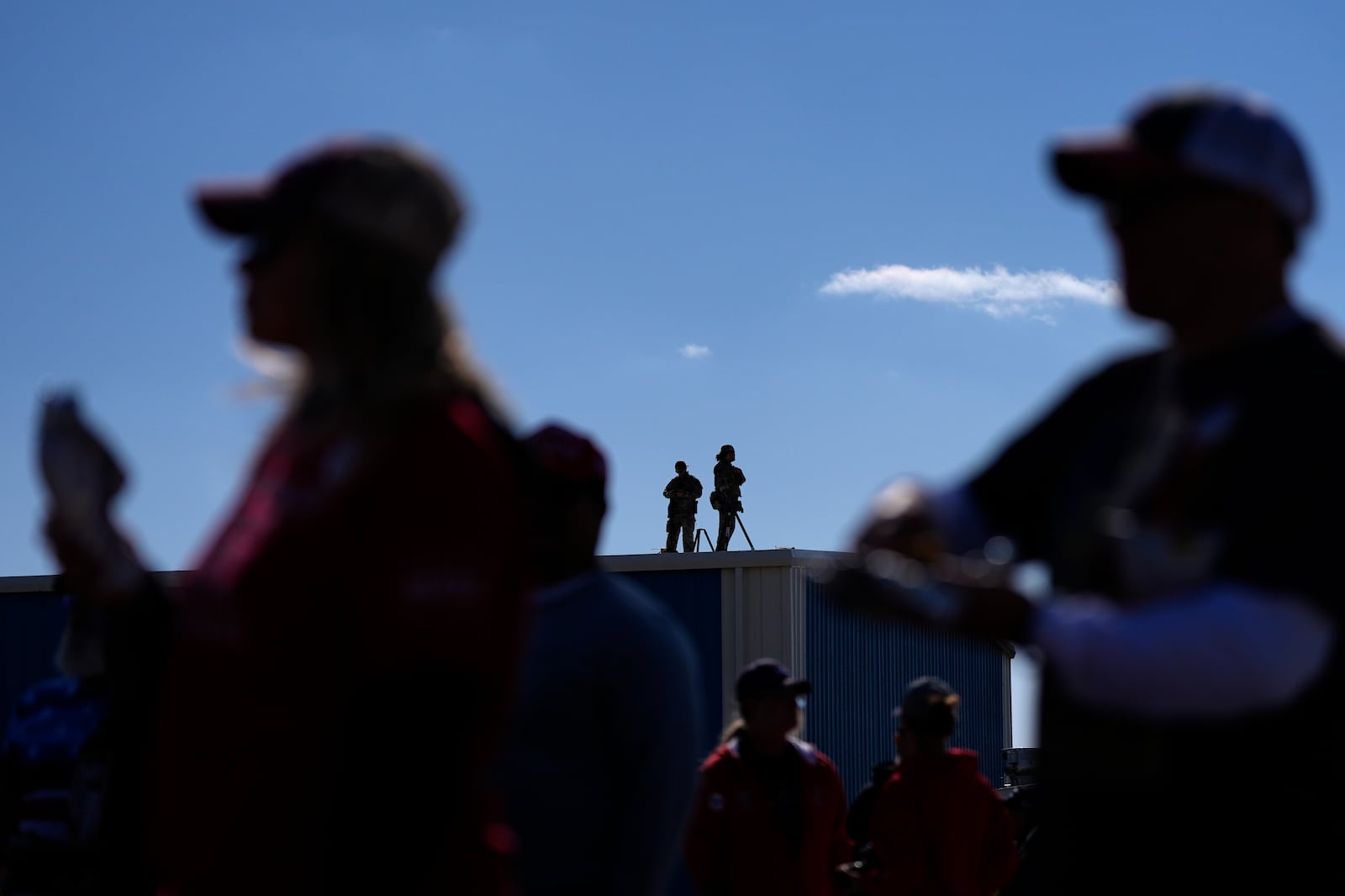 Law enforcement snipers stand on a roof as people wait for Republican presidential nominee former President Donald Trump to speak during a campaign rally at Dodge County Airport, Sunday, Oct. 6, 2024, in Juneau, Wis. (AP Photo/Julia Demaree Nikhinson)