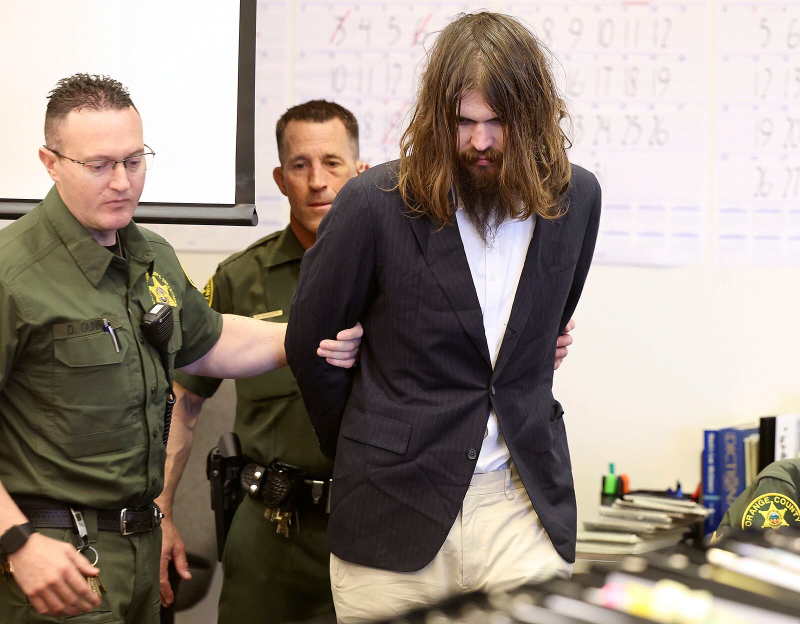 FILE - Orange County Deputy Sheriffs escort Samuel Woodward into Orange County Superior Court for opening statements of his murder trial for the stabbing death of Blaze Bernstein, Tuesday, April 9, 2024, in Santa Ana, Calif. (Frederick M. Brown/Pool Photo via Orange County Register, via AP, File)