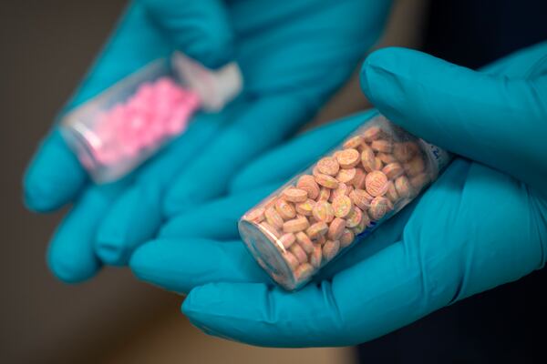 Jonathan Dumke, a senior forensic chemist with the Drug Enforcement Administration, holds vials of fentanyl pills at a DEA research laboratory on Tuesday, April 29, 2025, in Northern Virginia. (AP Photo/Mark Schiefelbein)