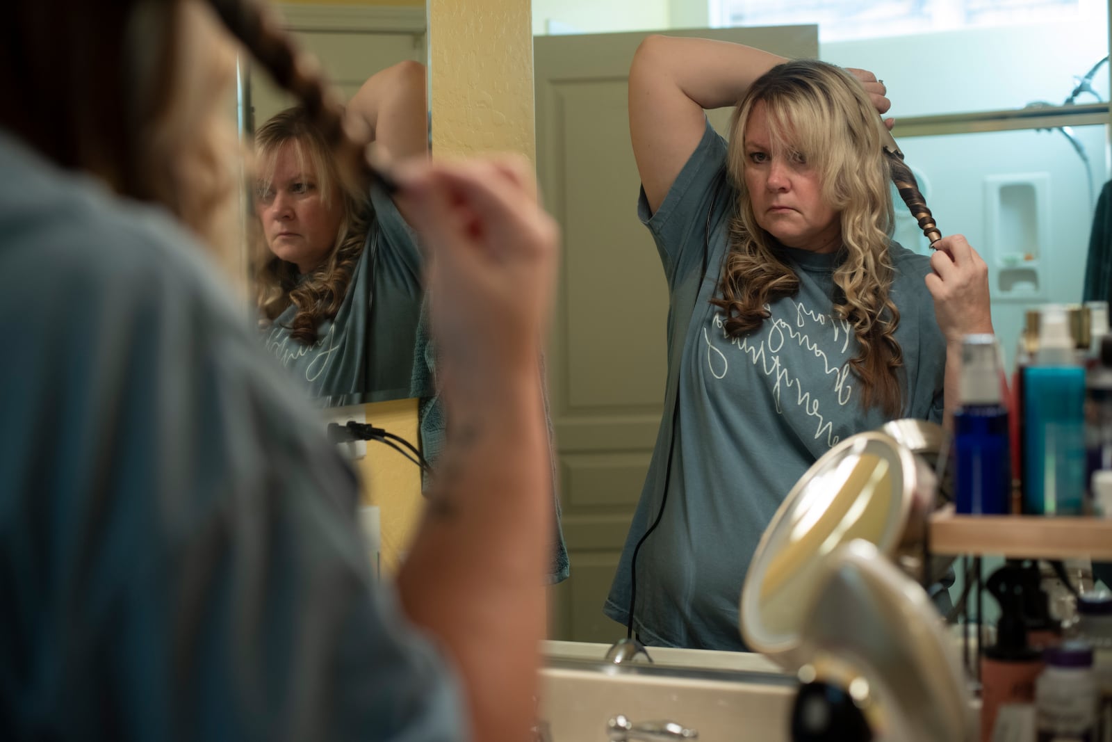 Cari-Ann Burgess, interim Registrar of Voters for Washoe County, Nev., curls her hair before church on Sunday, Sept. 22, 2024, in Reno, Nevada. (AP Photo/Serkan Gurbuz)