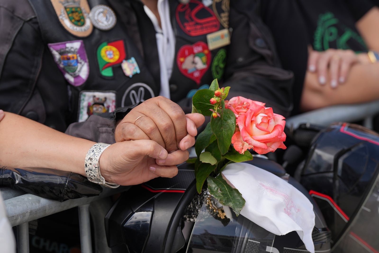 A couple hold hands while attending the IX Pilgrimage of the Blessing of Helmets that draws tens of thousands at the Roman Catholic holy shrine of Fatima, in Fatima, Portugal, Sunday, Sept. 22, 2024. (AP Photo/Ana Brigida)