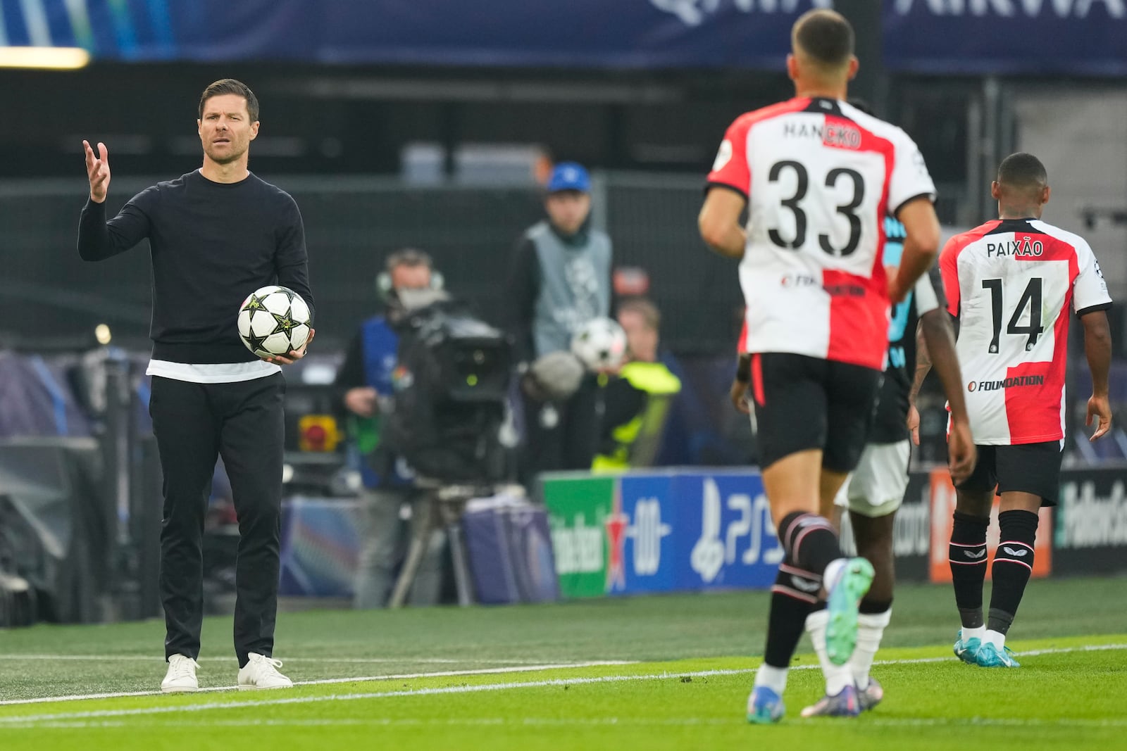 Leverkusen's head coach Xabi Alonso holds the ball during the Champions League opening phase soccer match between Feyenoord and Leverkusen in Rotterdam, Netherlands, Thursday, Sept. 19, 2024. (AP Photo/Peter Dejong)