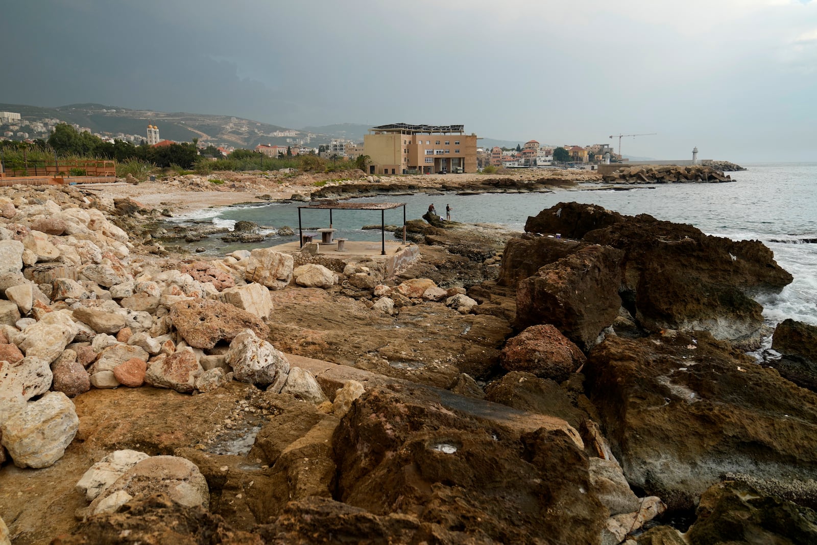 Lebanese fishermen cast their fishing rods at a beach in Batroun, northern Lebanon, Saturday, Nov. 2, 2024, where Lebanese officials say a ship captain was taken away by a group of armed men who landed on a coast north of Beirut and they're investigating whether Israel was involved. (AP Photo/Hussein Malla)