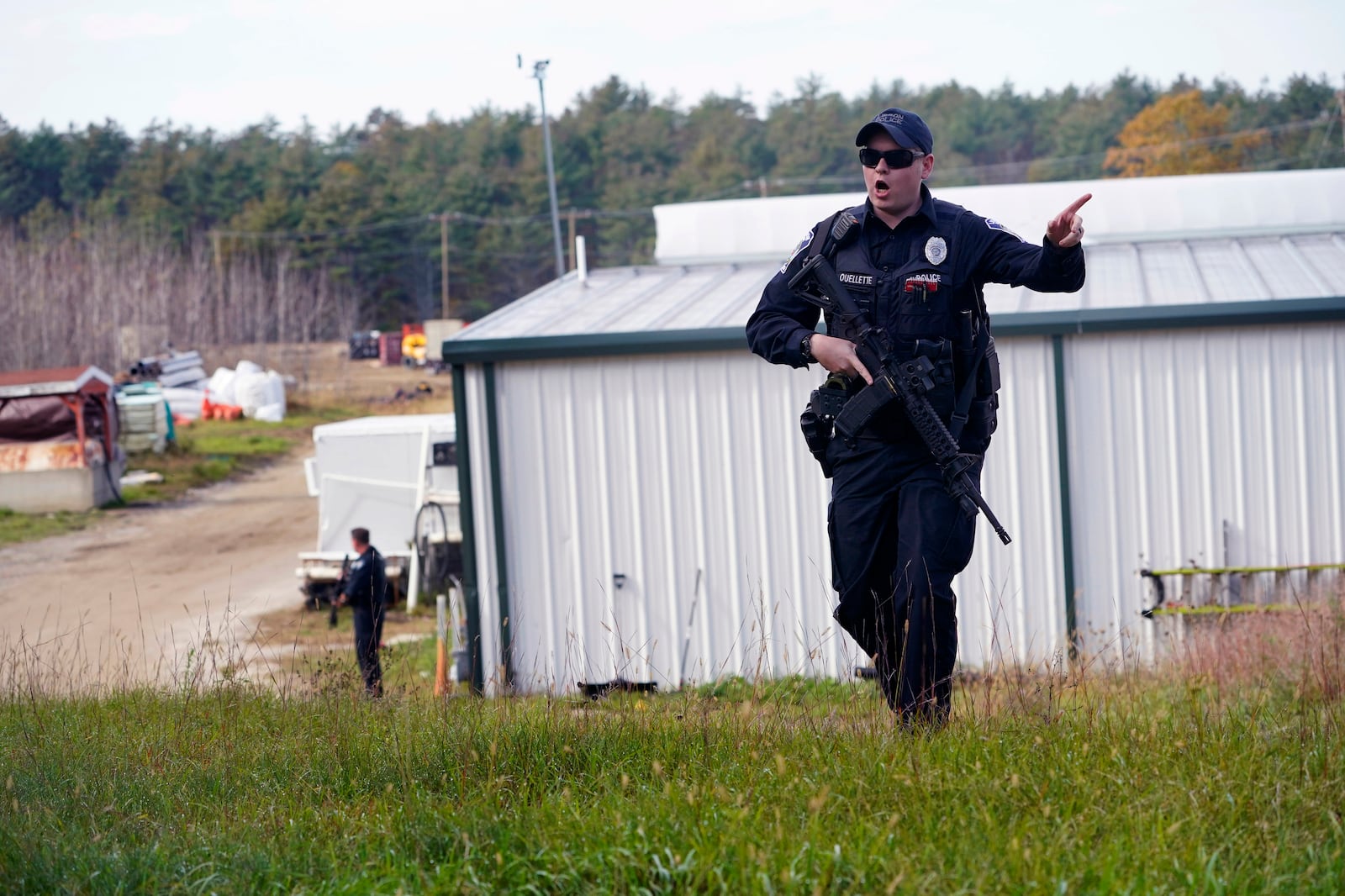 FILE - A police officer gives an order to the public during a manhunt for Robert Card at a farm following two mass shootings, in this Oct. 27, 2023 file photo, in Lisbon, Maine. (AP Photo/Robert F. Bukaty, File)