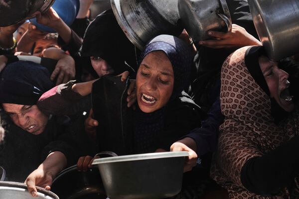 Palestinians struggle to obtain donated food at a community kitchen in Khan Younis, in the southern Gaza Strip, Friday, May 9, 2025. (AP Photo/Abdel Kareem Hana)