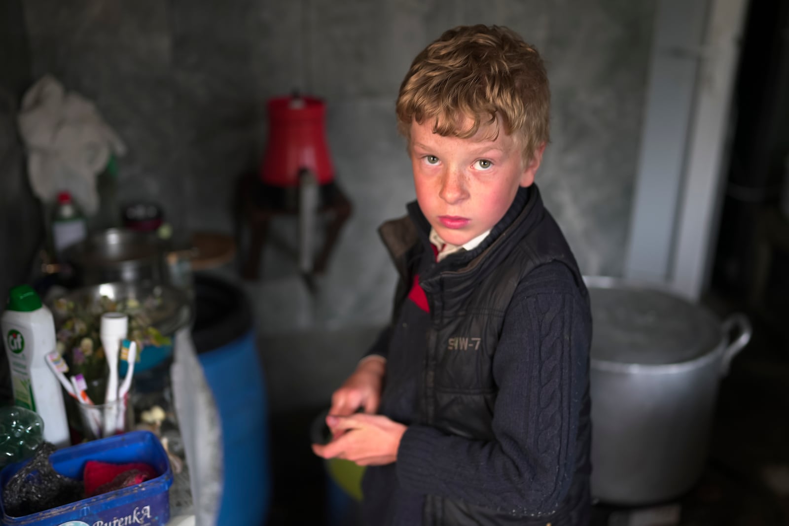 Ilya Strukov, 10, looks on in the kitchen as his family cooks dinner in their house in the remote mountain village of Orlovka, Georgia, Sunday, May 5, 2024. (AP Photo/Kostya Manenkov)