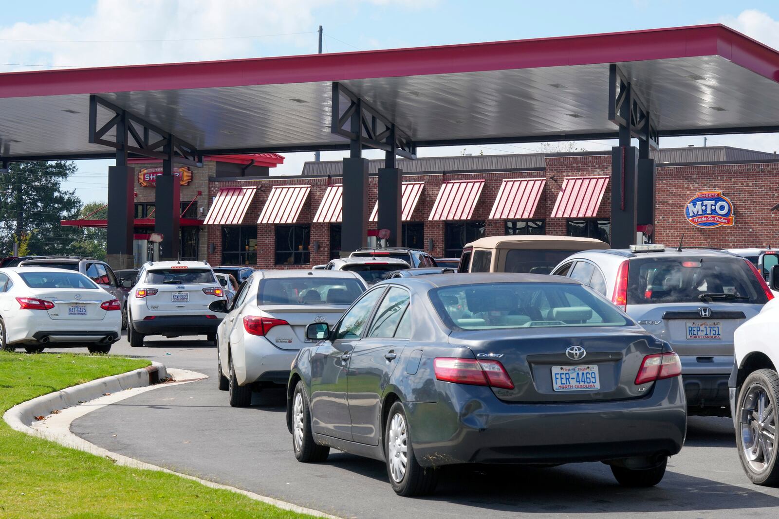 Long lines for gasoline are seen at a station Saturday, Sept. 28, 2024 in Morganton, N.C. The remnants of Hurricane Helene left area residents with no power, downed trees and lack of everyday necessities. (AP Photo/Kathy Kmonicek)