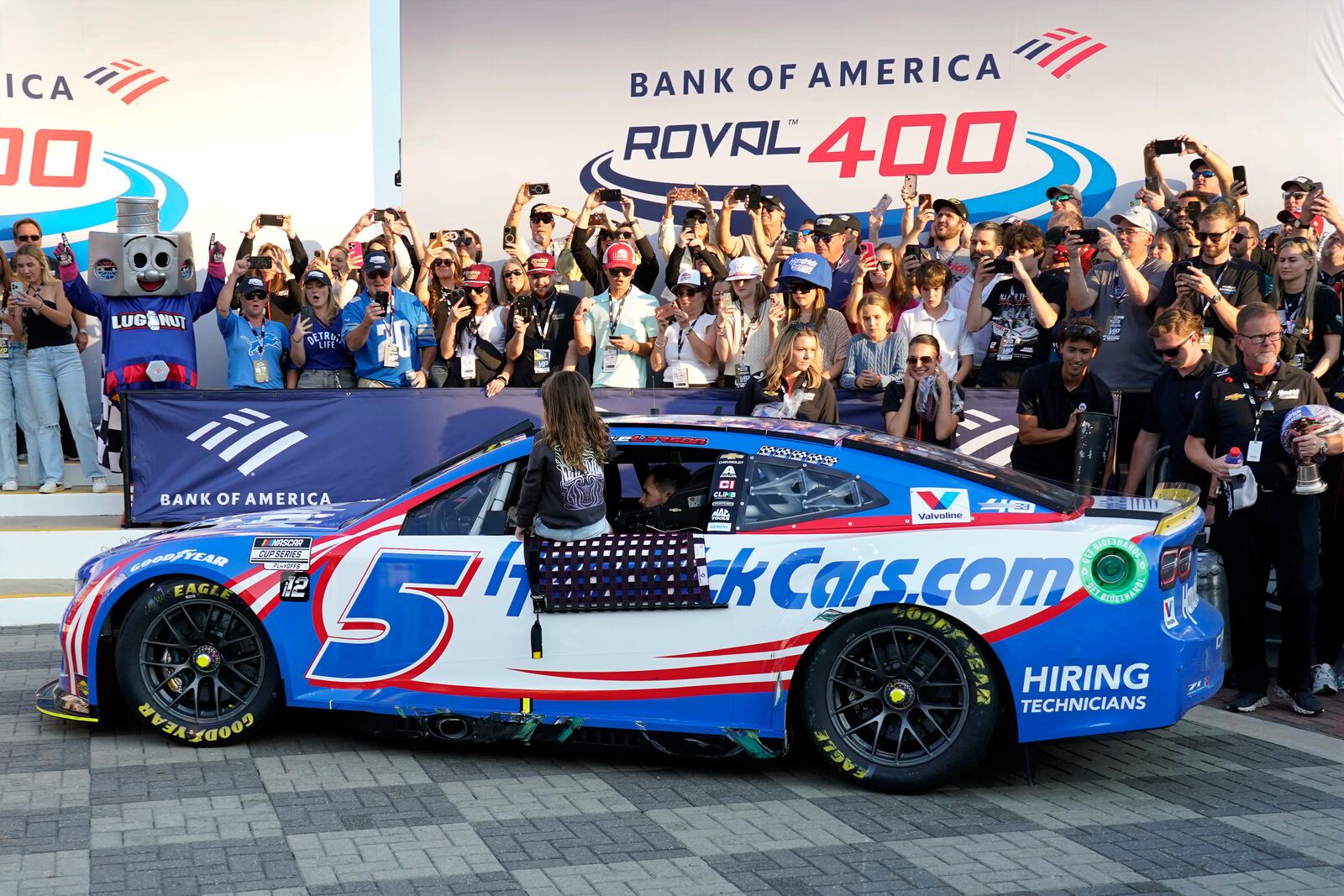 Kyle Larson drives into Victory Lane with his daughter Audrey, 6, after winning a NASCAR Cup Series auto race at Charlotte Motor Speedway in Concord, N.C., Sunday, Oct. 13, 2024. (AP Photo/Chuck Burton)