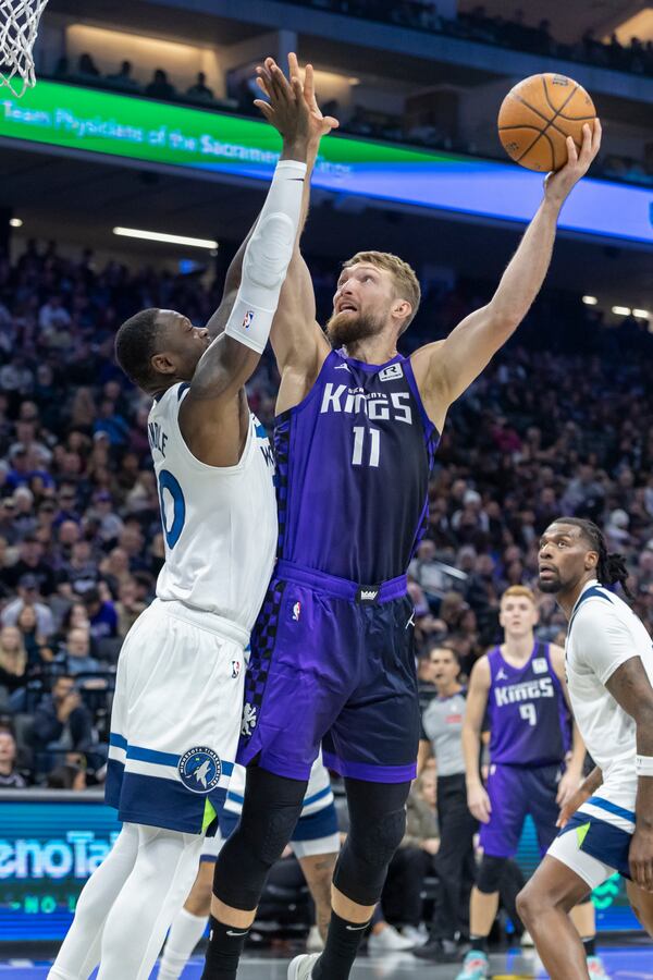 Sacramento Kings forward Domantas Sabonis (11) makes a layup over Minnesota Timberwolves forward Julius Randle, left, during the first half of an Emirates NBA Cup basketball game Friday, Nov. 15, 2024, in Sacramento, Calif. (AP Photo/Sara Nevis)