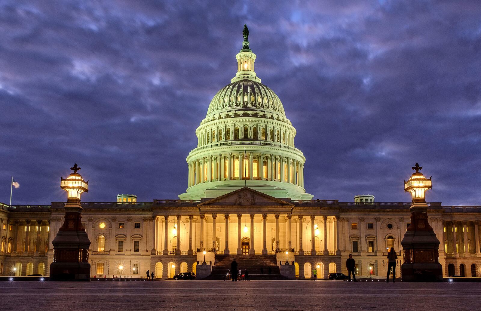 FILE - Lights shine inside the U.S. Capitol Building as night falls on Jan. 21, 2018, in Washington. (AP Photo/J. David Ake, File)