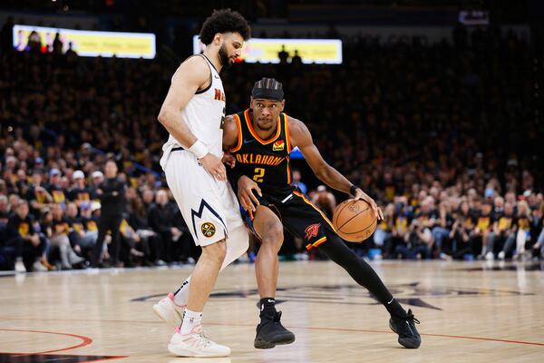 Oklahoma City Thunder's Shai Gilgeous-Alexander (2) works for a shot attempt as Denver Nuggets' Jamal Murray, left, defends in the second half of Game 1 of an NBA basketball second-round playoff series Monday, May 5, 2025, in Oklahoma City. (AP Photo/Nate Billings)