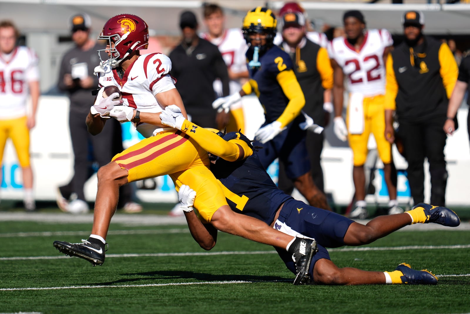 Southern California wide receiver Duce Robinson (2) is brought down by Michigan linebacker Jaishawn Barham (1) in the first half of an NCAA college football game in Ann Arbor, Mich., Saturday, Sept. 21, 2024. (AP Photo/Paul Sancya)