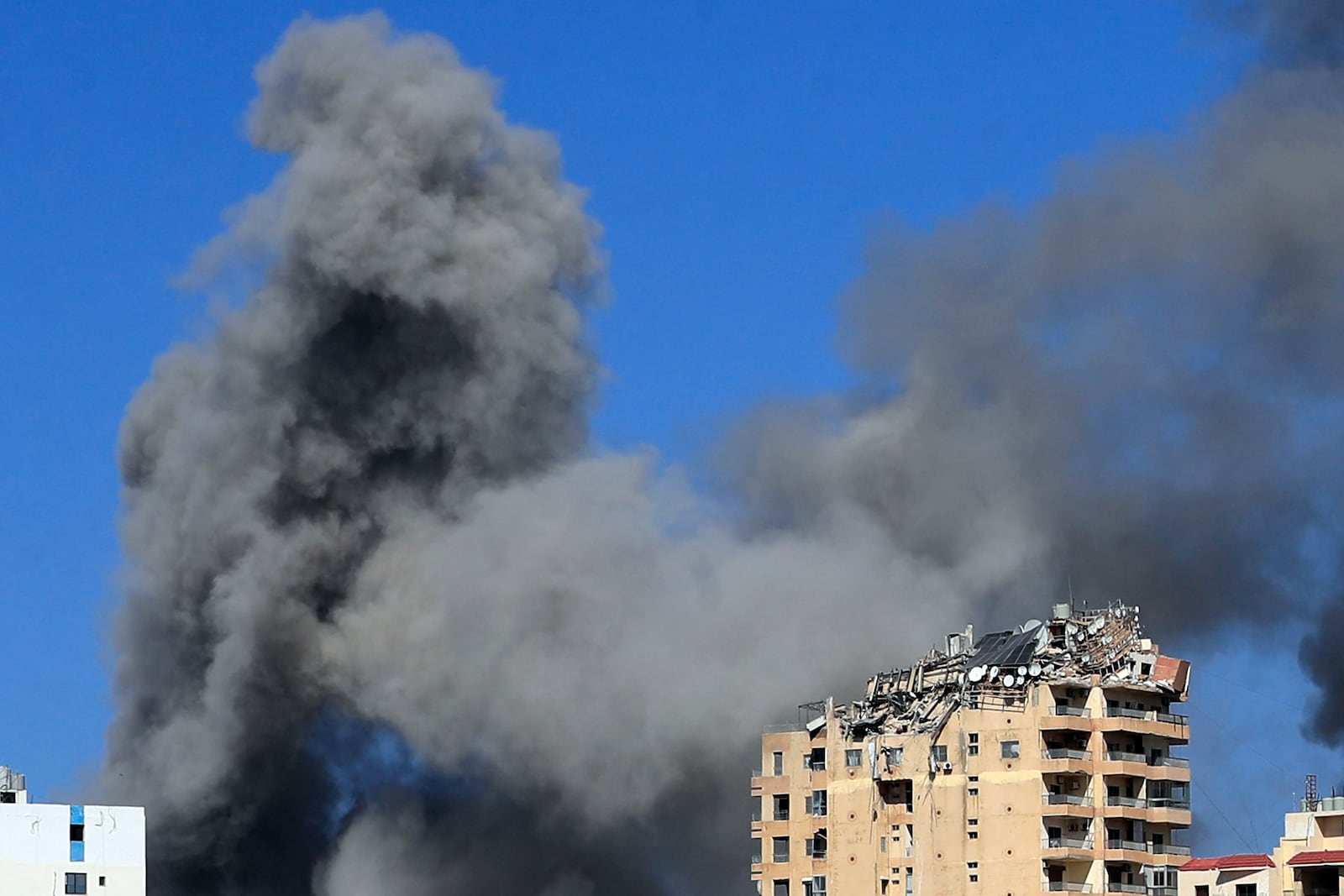 Smoke rises from buildings hit in Israeli airstrikes in Tyre, Lebanon, Wednesday, Oct. 23, 2024. (AP Photo/Mohammad Zaatari)