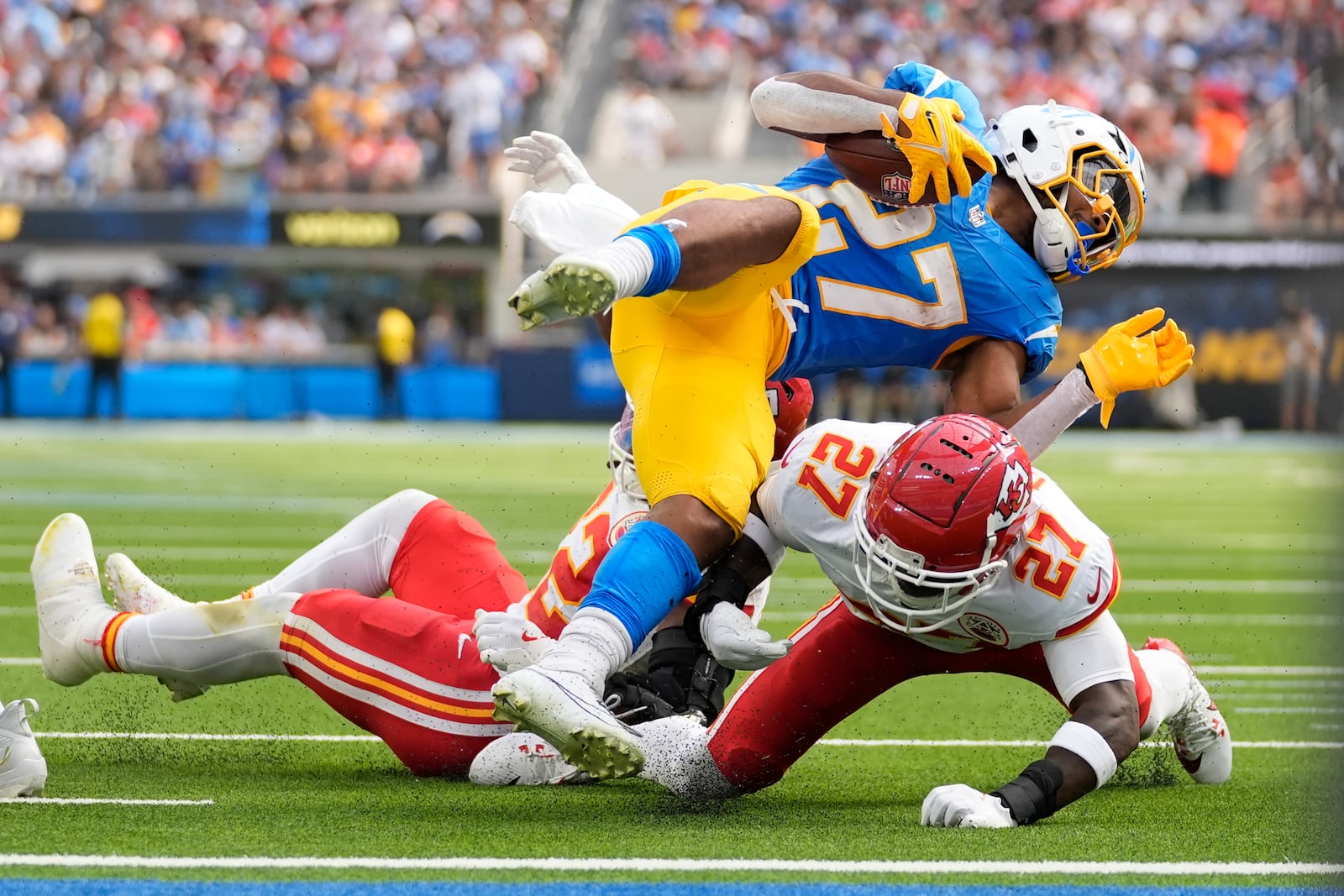 Los Angeles Chargers running back J.K. Dobbins, top, is stopped by Kansas City Chiefs defensive back Chamarri Conner, bottom, during the first half of an NFL football game Sunday, Sept. 29, 2024, in Inglewood, Calif. (AP Photo/Ashley Landis)