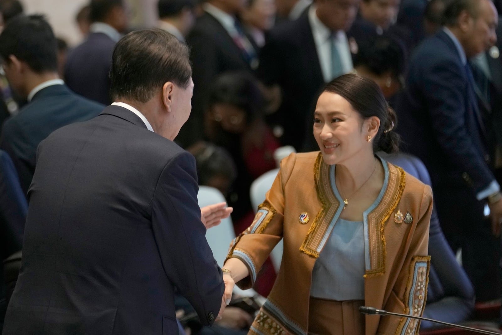 South Korean President Yoon, left, shakes hands with Thailand's Prime Minister Paetongtarn Shinawatra at the 25th ASEAN - South Korea Summit to commemorate the 35th Anniversary of Dialogue Relation in Vientiane, Laos, Thursday, Oct. 10, 2024. (AP Photo/Sakchai Lalit)