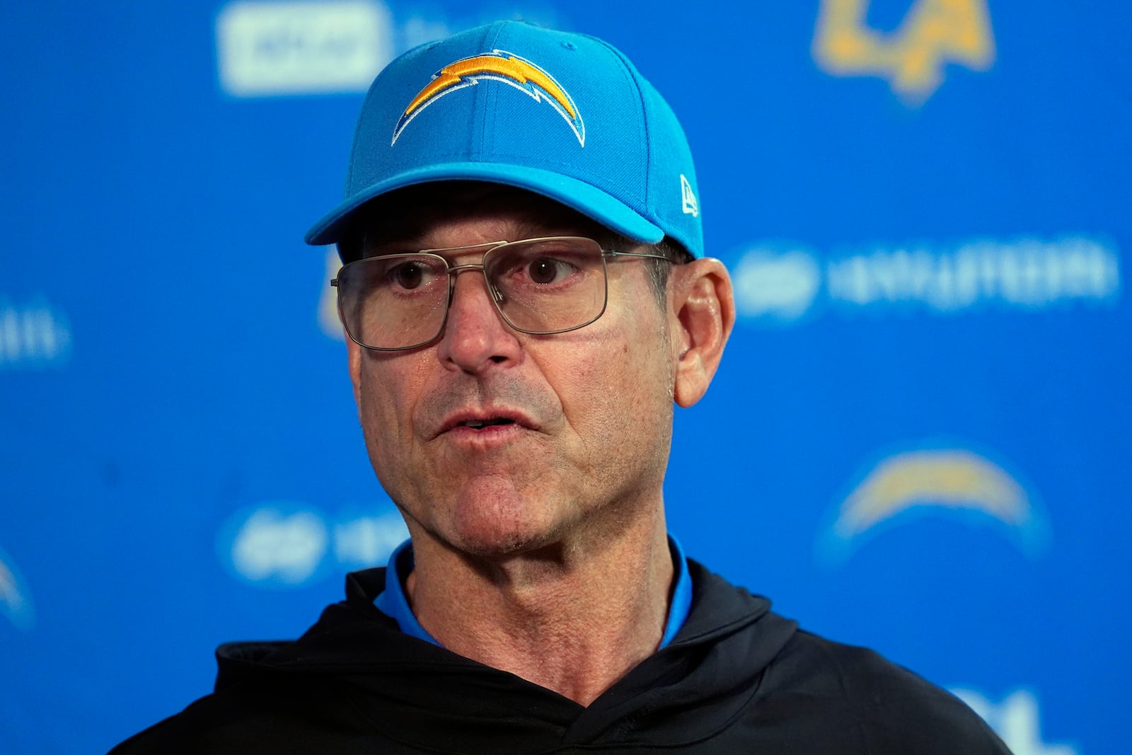 Los Angeles Chargers head coach Jim Harbaugh responds to a question during news conference after defeating the Denver Broncos in an NFL football game Sunday, Oct. 13, 2024, in Denver. (AP Photo/David Zalubowski)