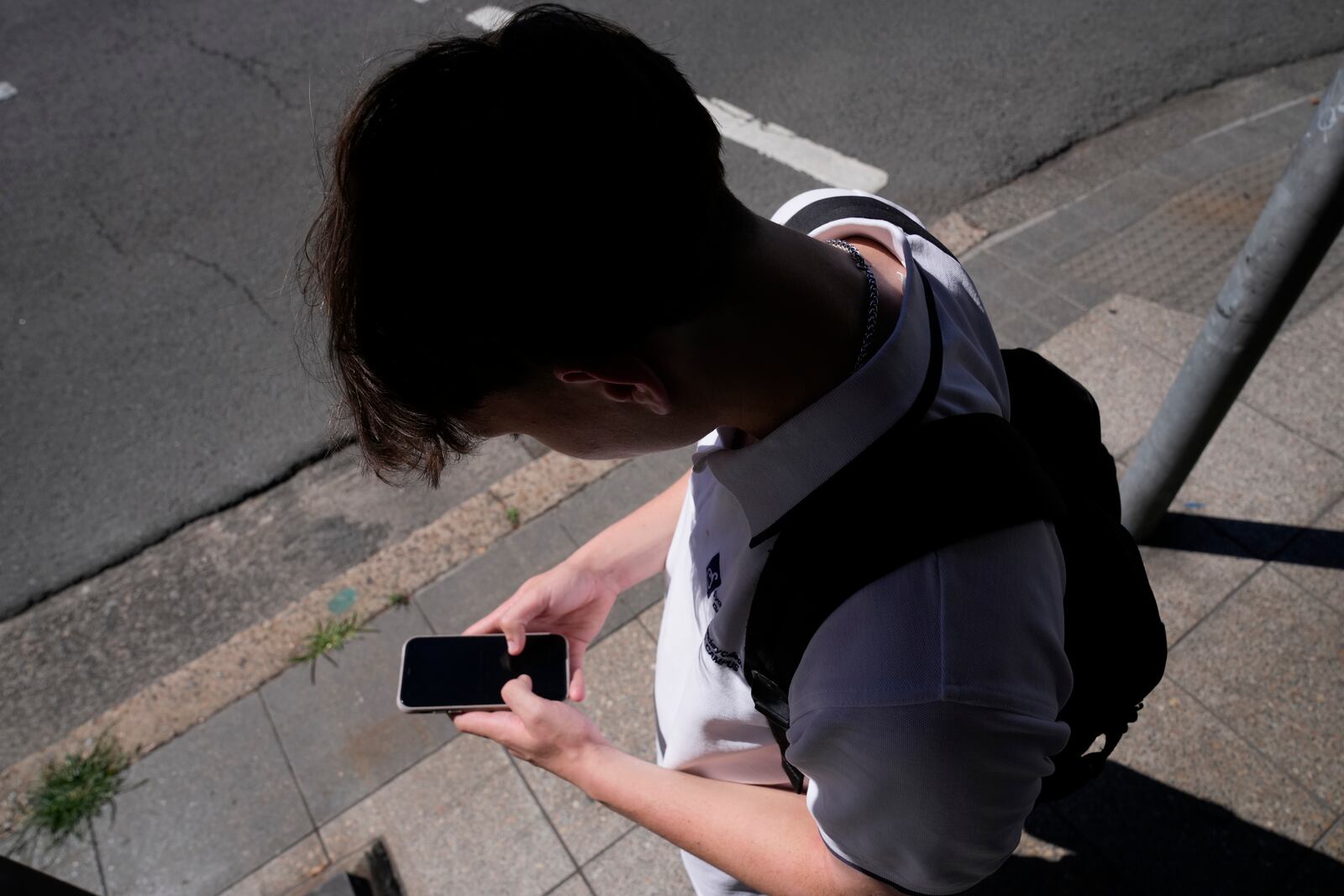 A teenage boy uses his phone in Sydney, Friday, Nov. 8, 2024. (AP Photo/Rick Rycroft)