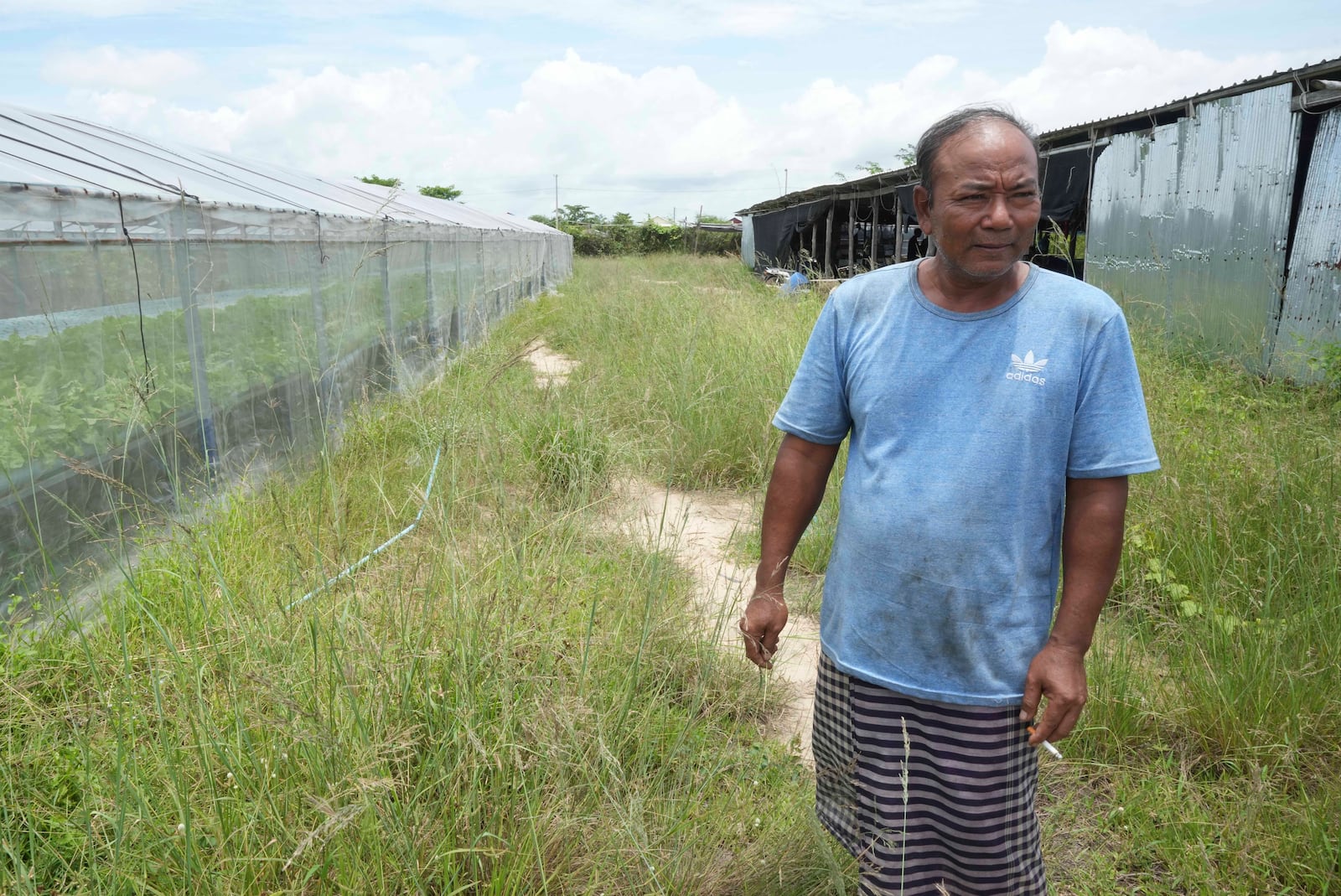 Em Phat, 53, stands in his eel farm at Tonle Sap complex, north of Phnom Penh, Cambodia, Wednesday, July 31, 2024. (AP Photo/Heng Sinith)