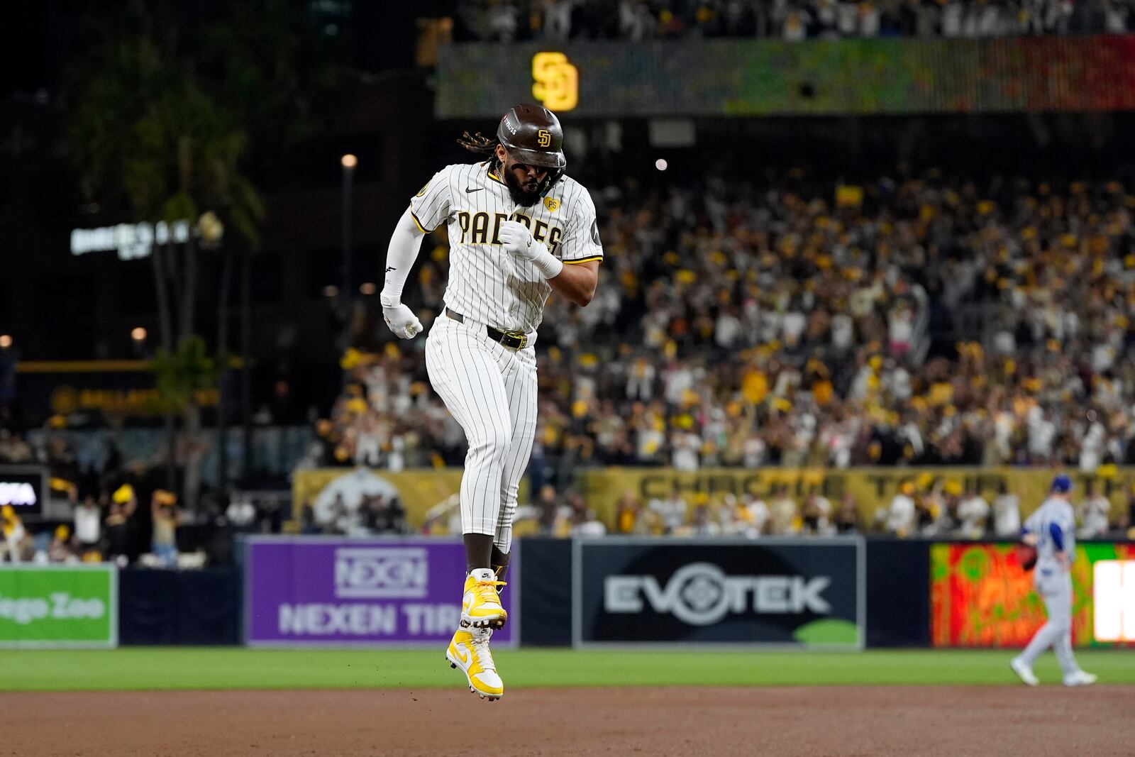 San Diego Padres' Fernando Tatis Jr. hops around third base after hitting a two-run home run during the second inning in Game 3 of a baseball NL Division Series against the Los Angeles Dodgers, Tuesday, Oct. 8, 2024, in San Diego. (AP Photo/Gregory Bull)