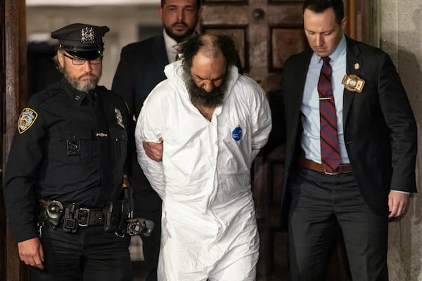 Ramon Rivera, a suspect arrested after multiple people were stabbed early Monday, is escorted out by NYPD officers at the NYPD 10th Precinct in New York, Monday, Nov. 18, 2024. (AP Photo/Yuki Iwamura)