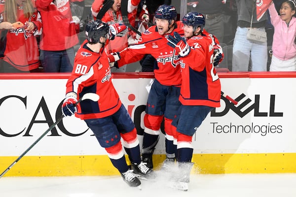 Washington Capitals right wing Brandon Duhaime (22) celebrates his empty net goal with left wing Pierre-Luc Dubois (80) and Connor McMichael, right, in the third period of Game 5 of a first-round NHL hockey playoff series against the Montreal Canadiens Wednesday, April 30, 2025, in Washington. (AP Photo/Nick Wass)