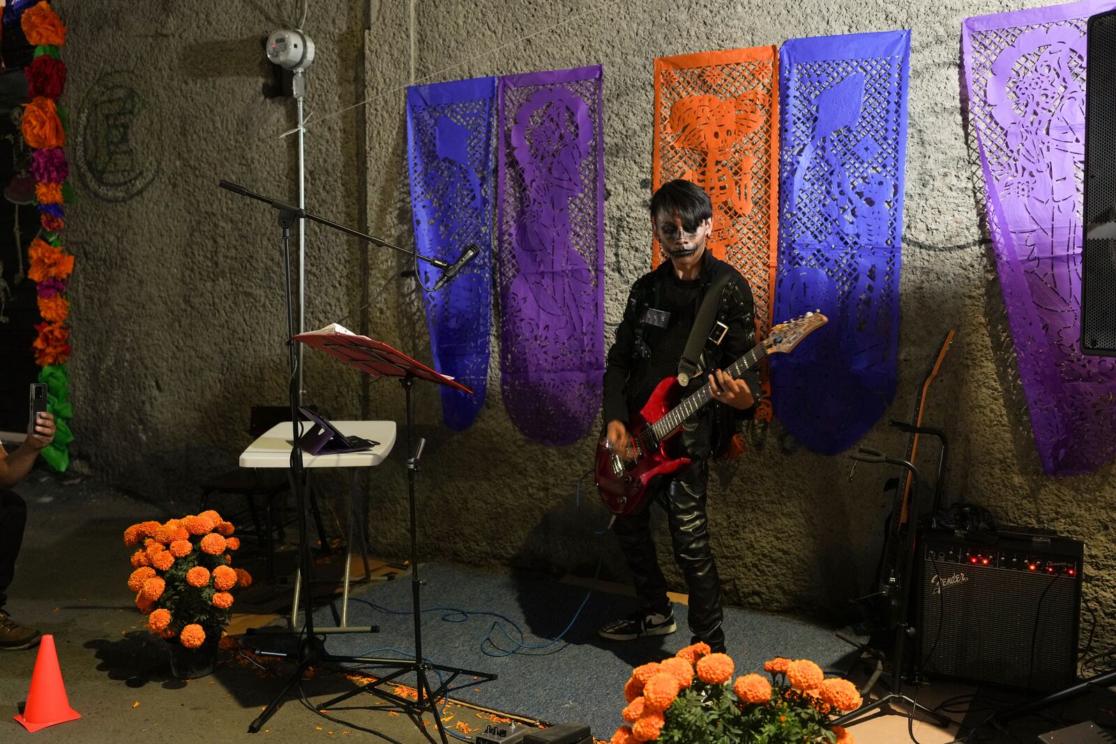 A musician performs people celebrate the Day of the Dead, near the San Gregorio Atlapulco cemetery on the outskirts of Mexico City, Friday, Nov. 1, 2024. (AP Photo/Moises Castillo)