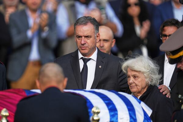 Uruguayan President Yamandu Orsi, left, stands with Lucia Topolansky, widow of the late, former President Jose Mujica, next to his casket at the presidential palace in Montevideo, Uruguay, Wednesday, May 14, 2025. (AP Photo/Matilde Campodonico)