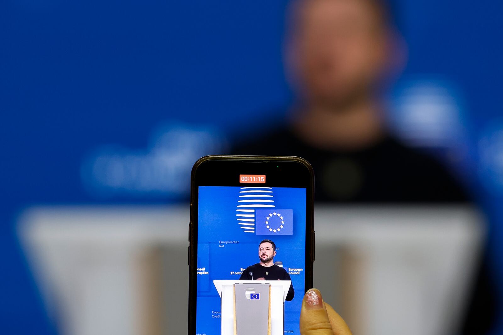 A journalist uses her phone to record a press conference of Ukraine's President Volodymyr Zelenskyy during an EU summit in Brussels, Thursday, Oct. 17, 2024. (AP Photo/Geert Vanden Wijngaert)