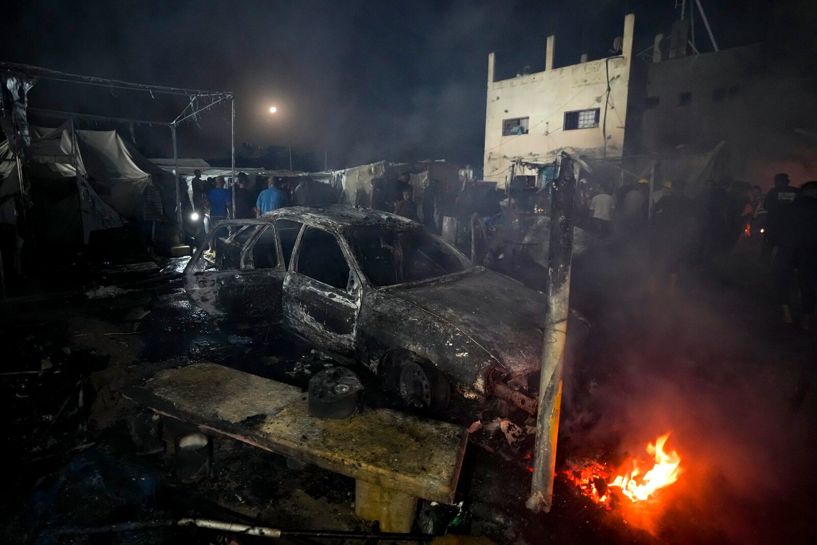 Palestinians inspect the damage at a tent area in the courtyard of Al Aqsa Martyrs hospital, hit by an Israeli bombardment on Deir al-Balah, central Gaza Strip, Monday, Oct. 14, 2024. (AP Photo/Abdel Kareem Hana)