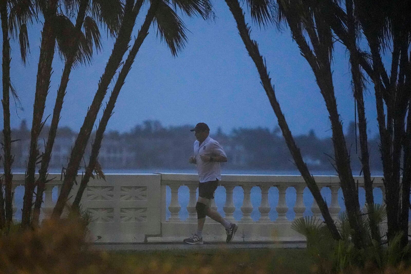 A jogger runs along the bay in heavy rain ahead of Hurricane Milton, Wednesday, Oct. 9, 2024, in Tampa, Fla. (AP Photo/Mike Stewart)