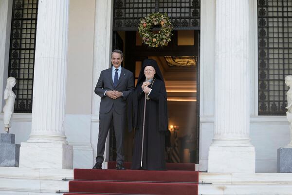 Greece's Prime Minister Kyriakos Mitsotakis, left, and the Orthodox Ecumenical Patriarch Bartholomew pose for photographers before their meeting in Athens, on Thursday May 8, 2025. (AP Photo/Petros Giannakouris)