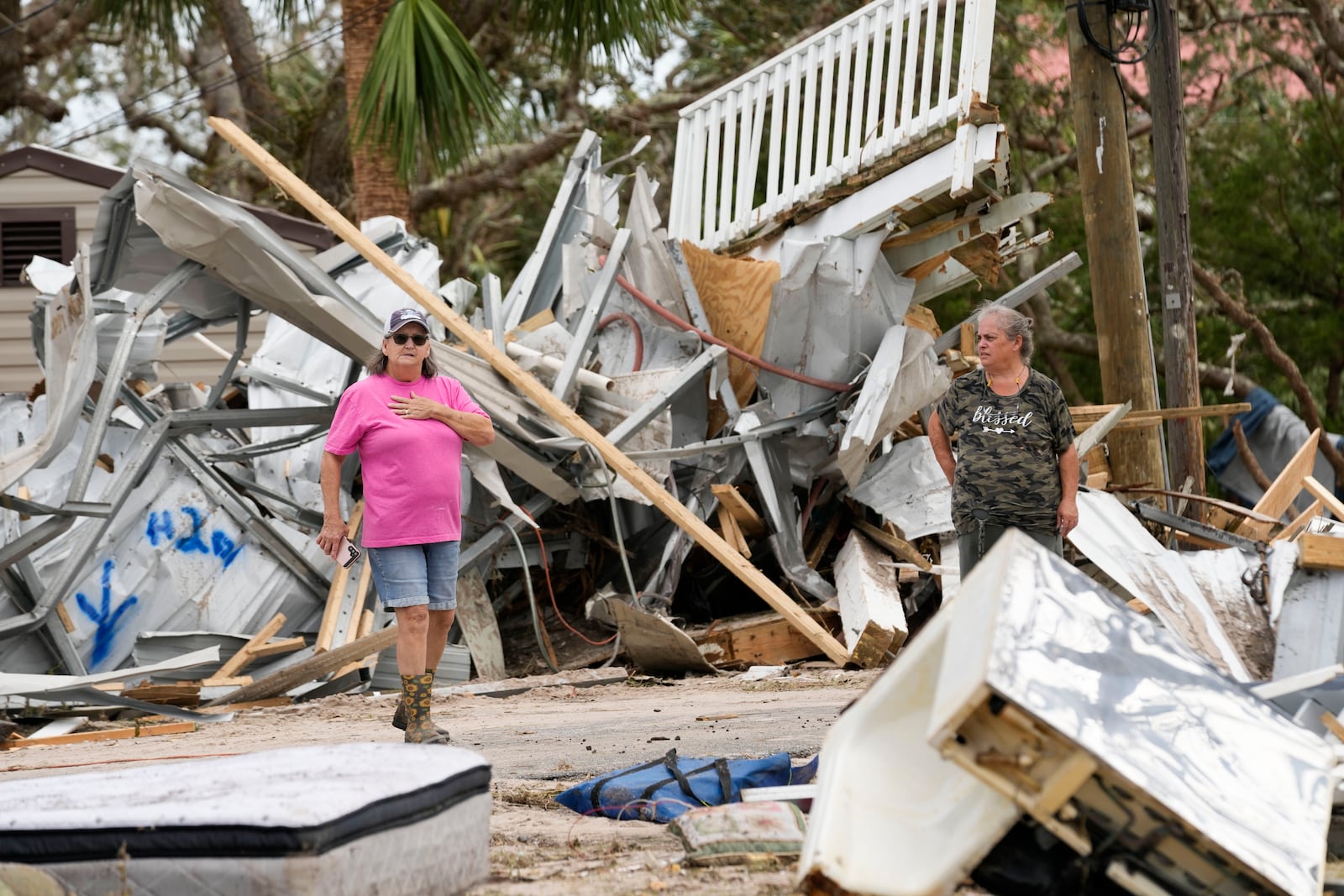 Frankie Johnson, left, talks with fellow resident Charlene Huggins, whose home was destroyed, amid the destruction in the aftermath of Hurricane Helene, in Horseshoe Beach, Fla., Saturday, Sept. 28, 2024. (AP Photo/Gerald Herbert)