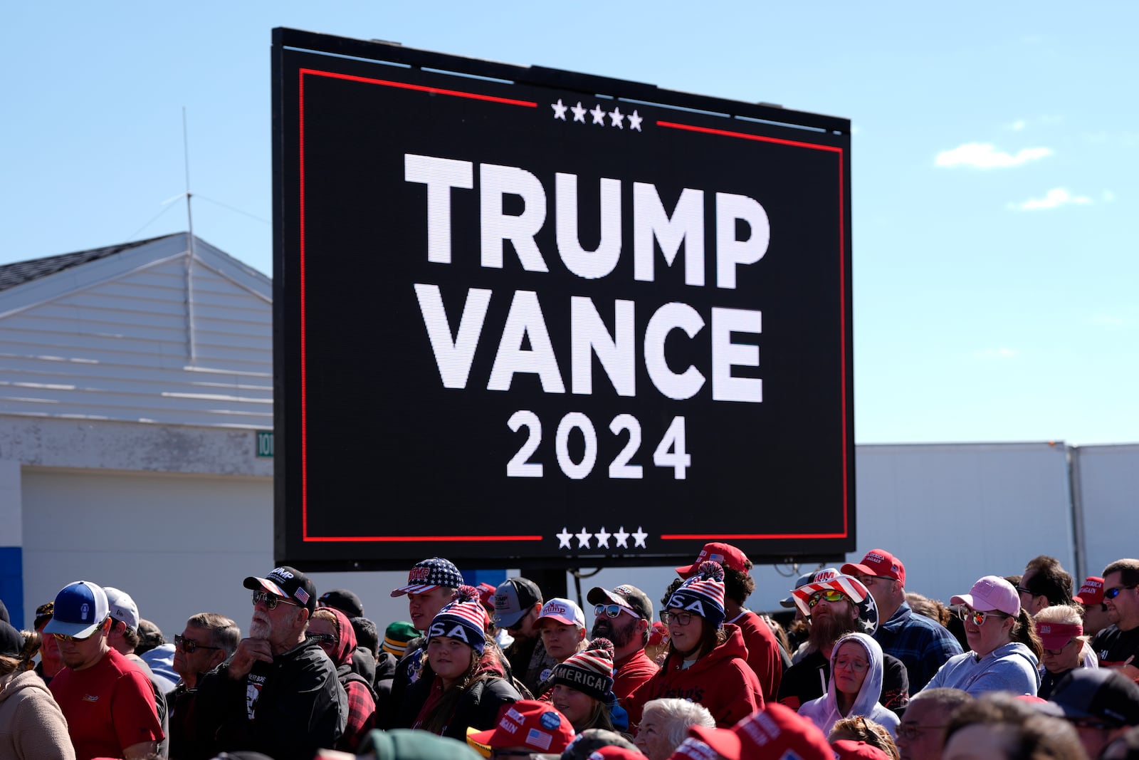 People wait for Republican presidential nominee former President Donald Trump to speak during a campaign rally at Dodge County Airport, Sunday, Oct. 6, 2024, in Juneau, Wis. (AP Photo/Julia Demaree Nikhinson)