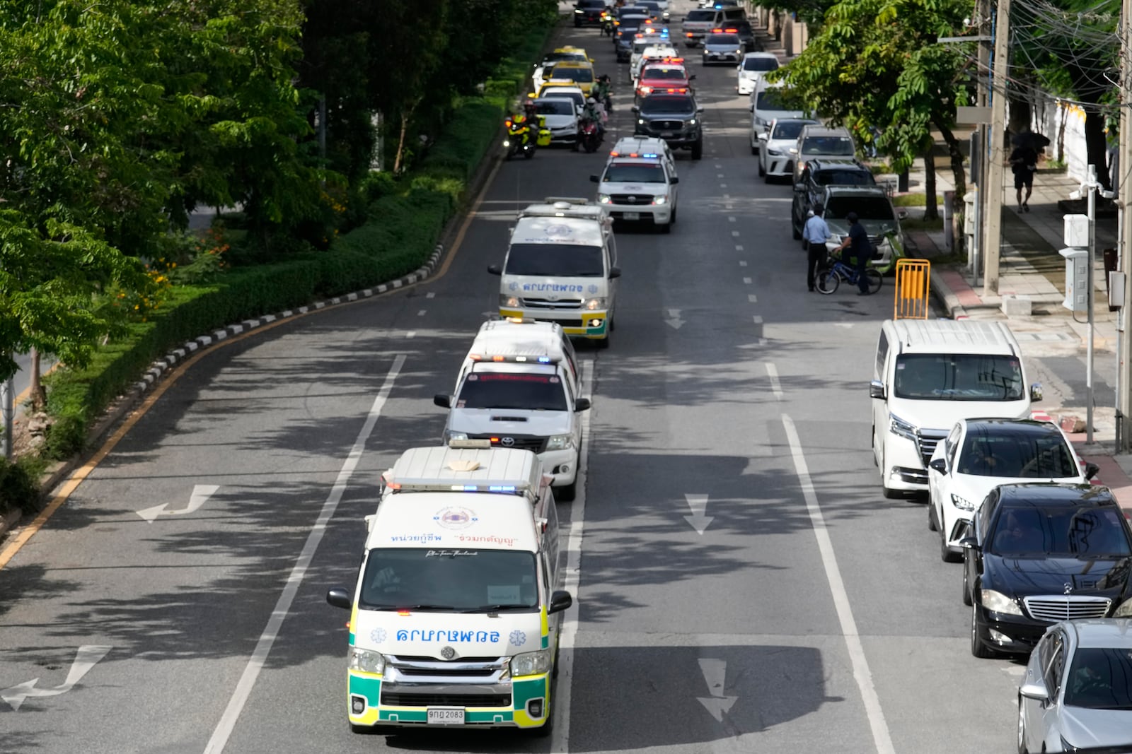 Ambulances carrying bodies of victims of a school bus fire leave from the Police hospital in Bangkok, Thailand, Wednesday, Oct. 2, 2024. (AP Photo/Sakchai Lalit)